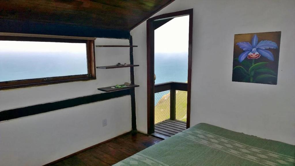 um quarto com um quarto com uma janela e uma cama em Casa no Pontal do Atalaia - ESPETACULAR em Arraial do Cabo