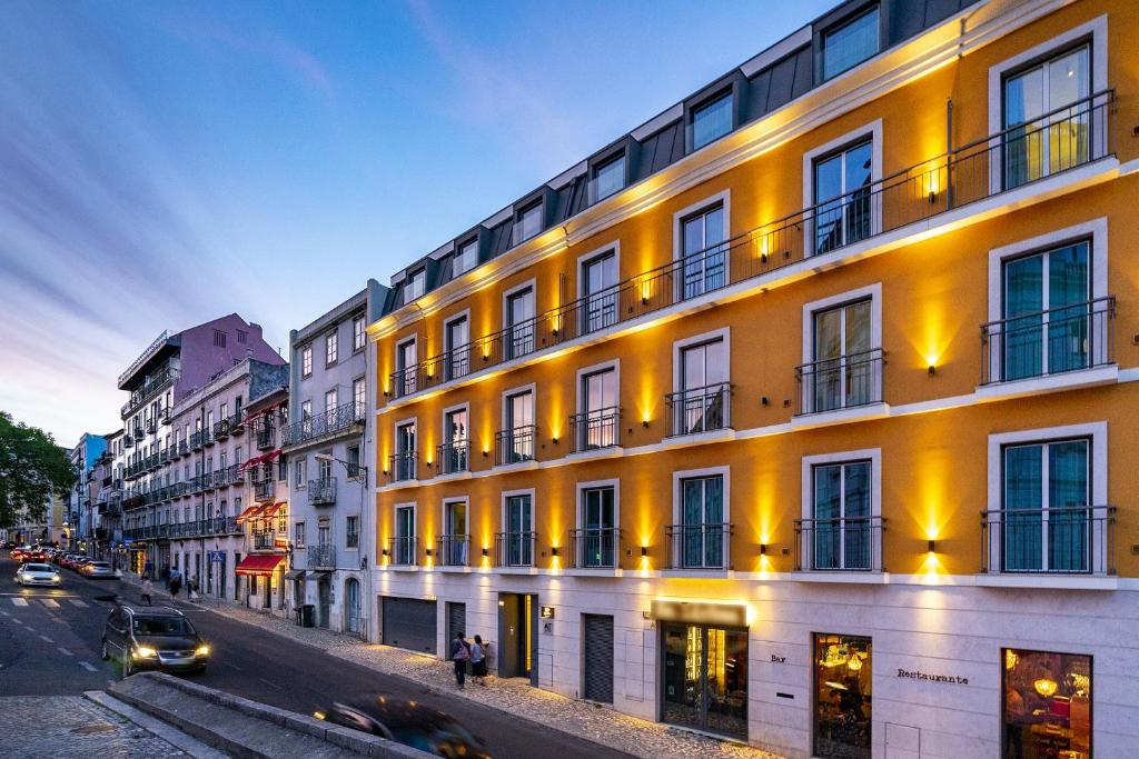 Les Deux Mariettes São Bento في لشبونة: مبنى على جانب شارع فيه سيارات