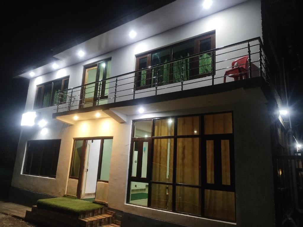 una casa por la noche con balcón en Tip Top Pahalgam, en Pahalgām