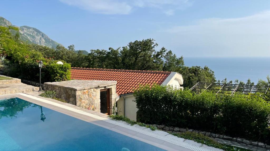 a swimming pool in front of a house at House in the Mountains near Budva in Budva