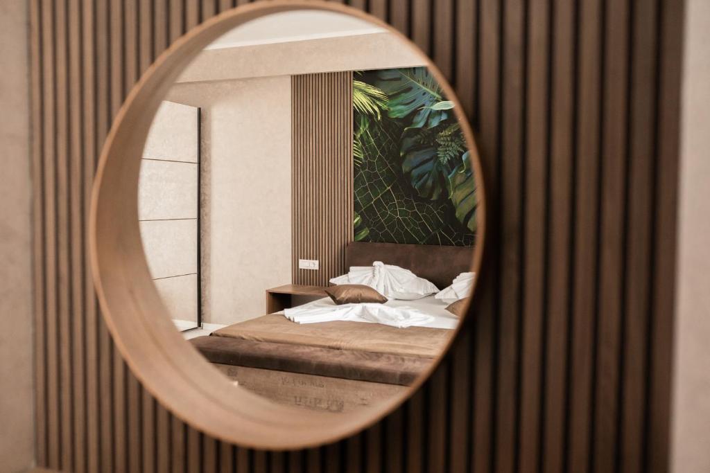 um espelho que reflecte uma cama num quarto em TUDOR BY DEDAL APARTHOTEL em Năvodari