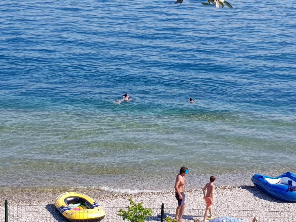 un grupo de personas en el agua en la playa en Sereno Camping Holiday, en Moniga del Garda