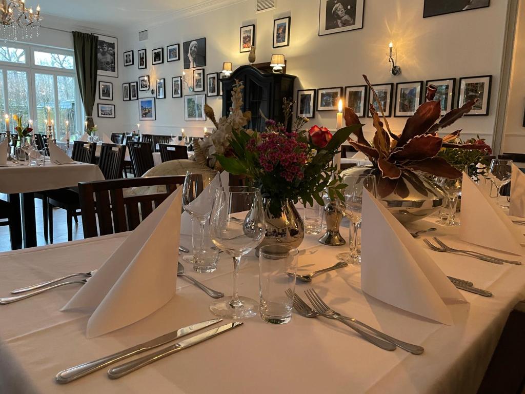 une table avec des serviettes blanches et des fleurs au-dessus dans l'établissement dS Hotel Restaurant Gronau, à Gronau