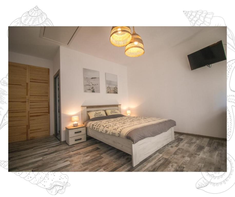 a bedroom with a bed and a television and lights at Flip Flop Bungalows in Vadu