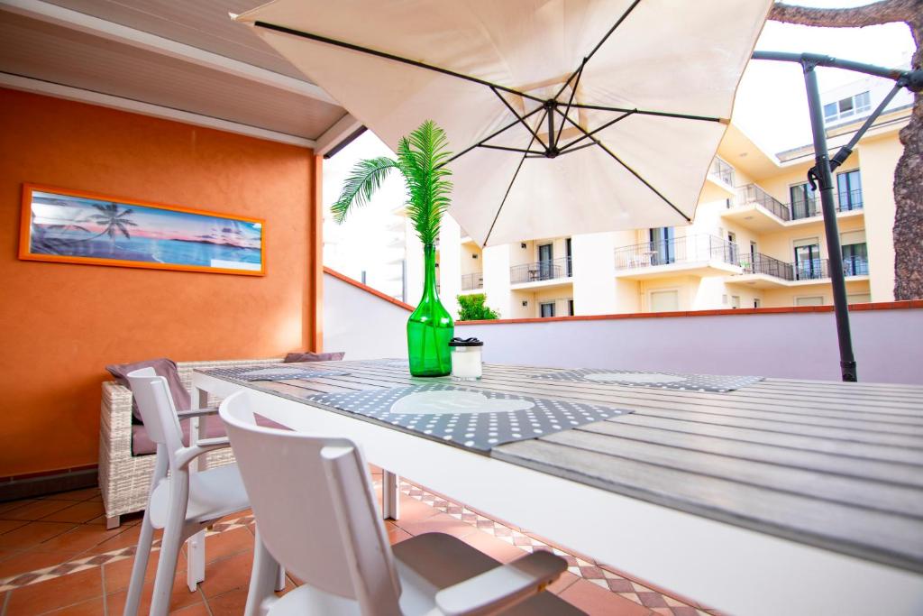 ein Esszimmer mit einem Tisch mit einer Palme in einer grünen Flasche in der Unterkunft Prime blue suite - Giardini in Riccione