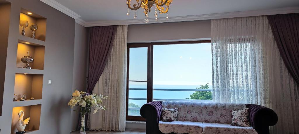 a living room with a couch and a large window at Ayliya hause in Akcaabat