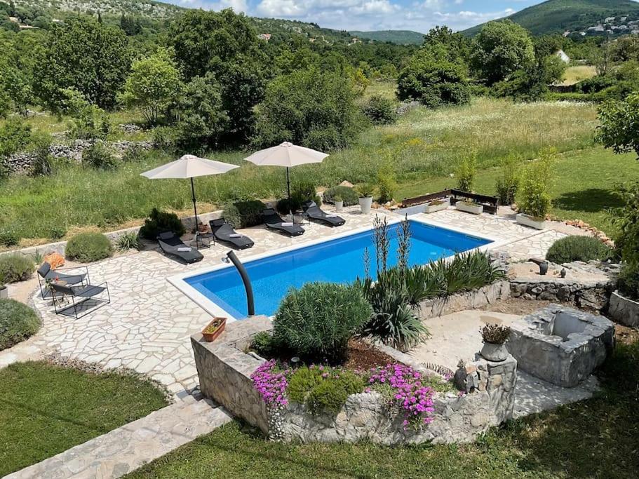 una piscina con sillas y sombrillas en un patio en Finca DIDA, en Brštanovo