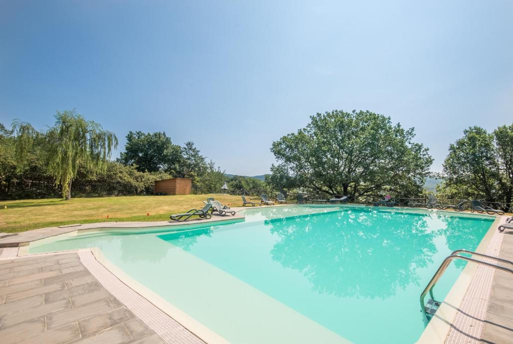 a large swimming pool with blue water at Fortilizio di Campiglia Il Pero in Rapolano Terme