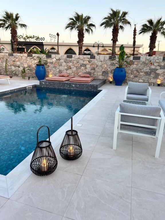 duas luzes ao lado de uma piscina com uma cadeira em Cora May Central Villa with private pool 200m to the beach em Faliraki
