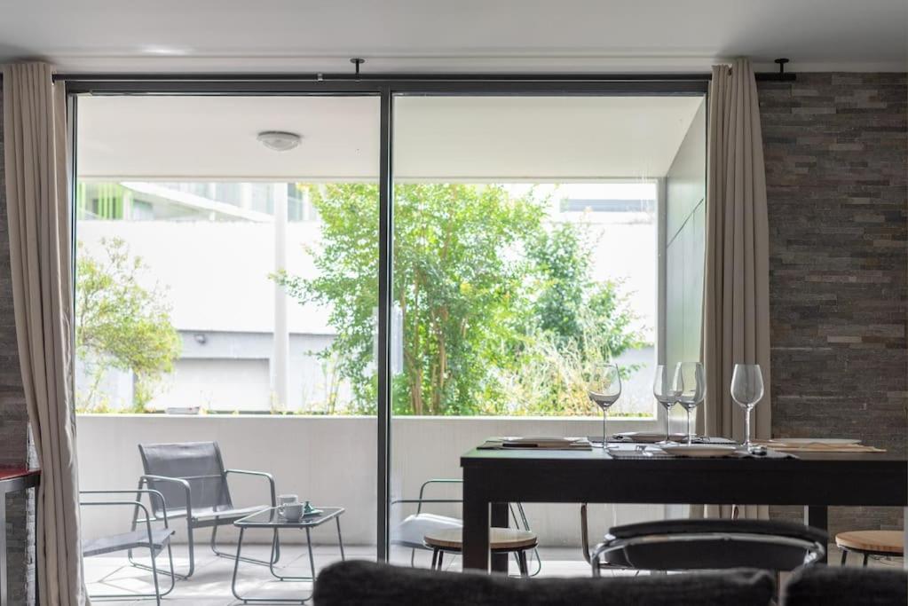 une salle à manger avec une table et des chaises et une grande fenêtre dans l'établissement T3 Terrasse + parking - proche Aéroport et MEET, à Blagnac
