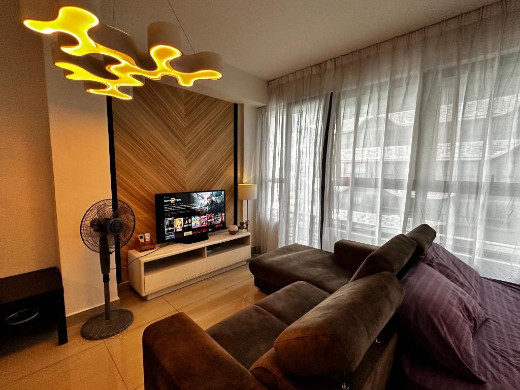 - un salon avec un canapé et une télévision dans l'établissement Comfy Family Suite ArtePlus Jalan Ampang, à Kuala Lumpur