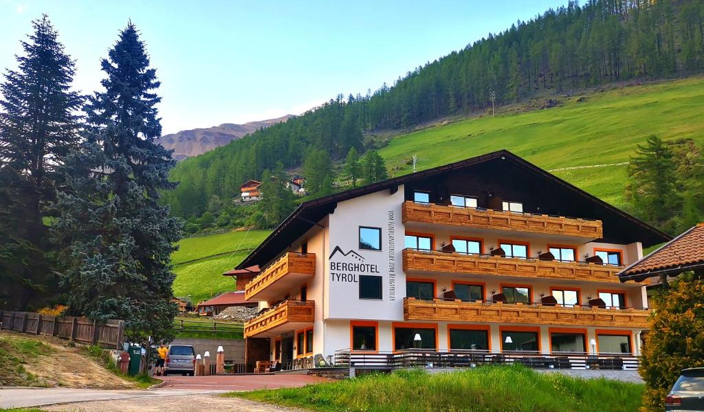 セナーレスにあるBerghotel Tyrolの山の上に木製バルコニー付きの大きな建物