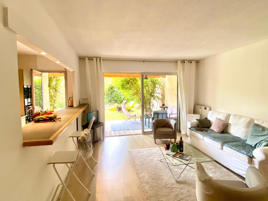 ein Wohnzimmer mit einem Sofa und einem Tisch in der Unterkunft Cashmere, Aix en Provence grand T2 avec jardin en ville in Aix-en-Provence