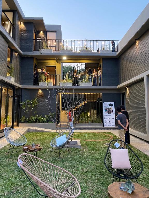 a house with a yard with chairs and people on a balcony at Moderno departamento frente a ciudad cultural II in San Salvador de Jujuy