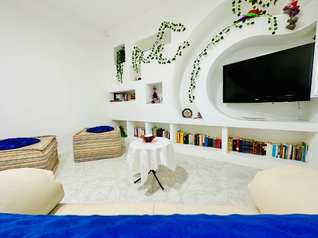 uma sala de estar com uma televisão, um sofá e uma mesa em FAR WEST em Ginosa