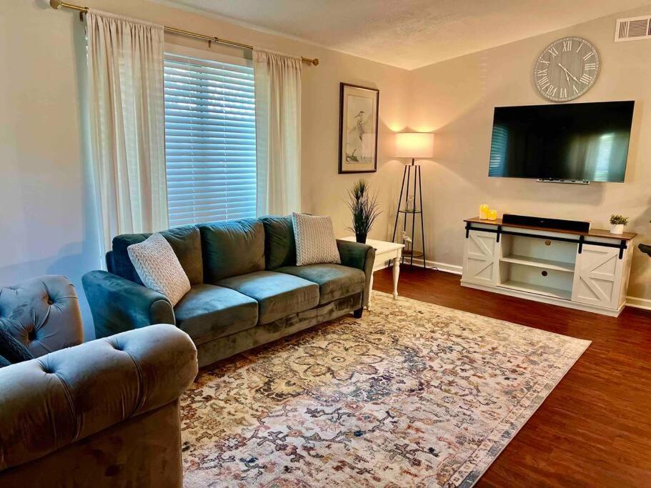 a living room with a couch and a tv at Cozy Coastal Cottage in Heart of St. Augustine in St. Augustine