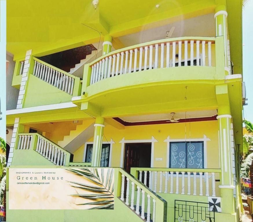 a yellow house with a balcony on the side of it at Green House Stay in Mandrem