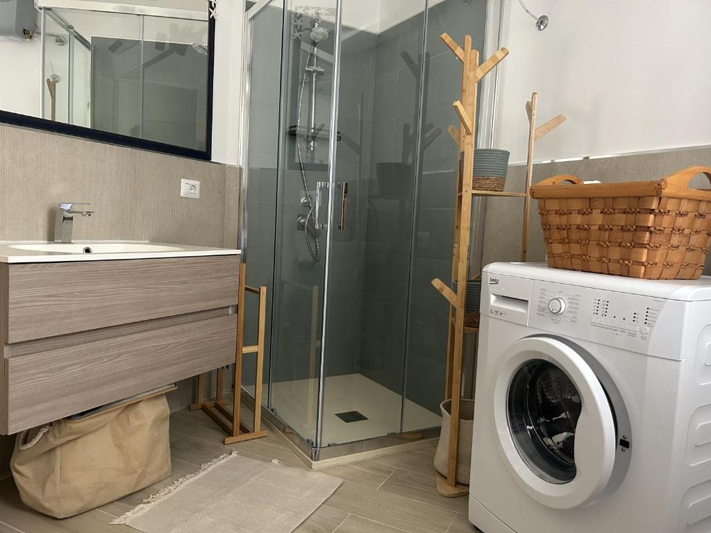 een badkamer met een wasmachine en een wastafel bij Appartamento Sole Blu in Alghero