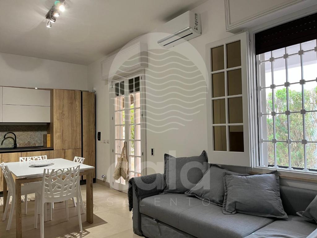 een woonkamer met een bank en een tafel bij Villa Areia - Spiaggia a 10m By Cala Salento in Porto Cesareo