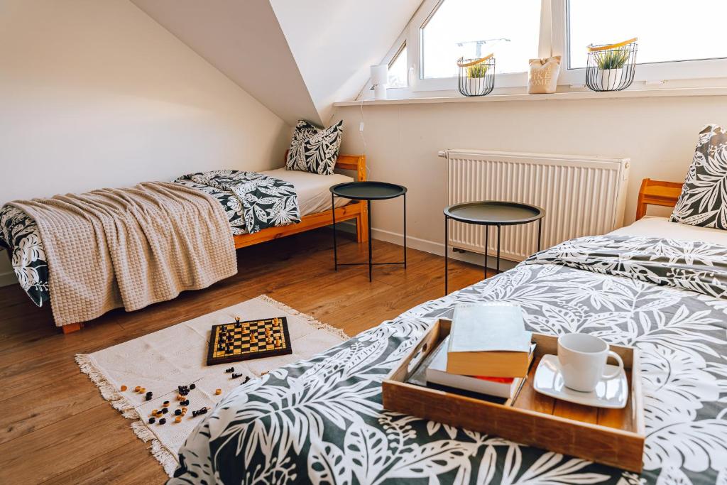 een slaapkamer met 2 bedden en een dienblad met boeken bij Apartament Loft nad Rzeką 3 pokojowy in Ustroń