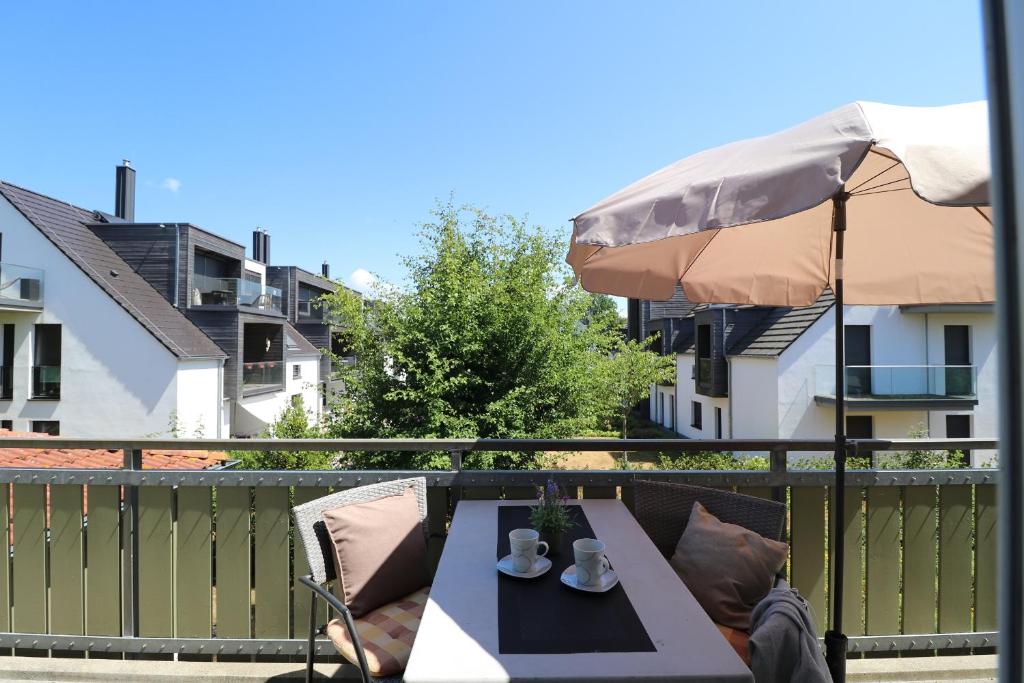 a table on a balcony with an umbrella at Altes Wasserwerk App 20 in Wustrow