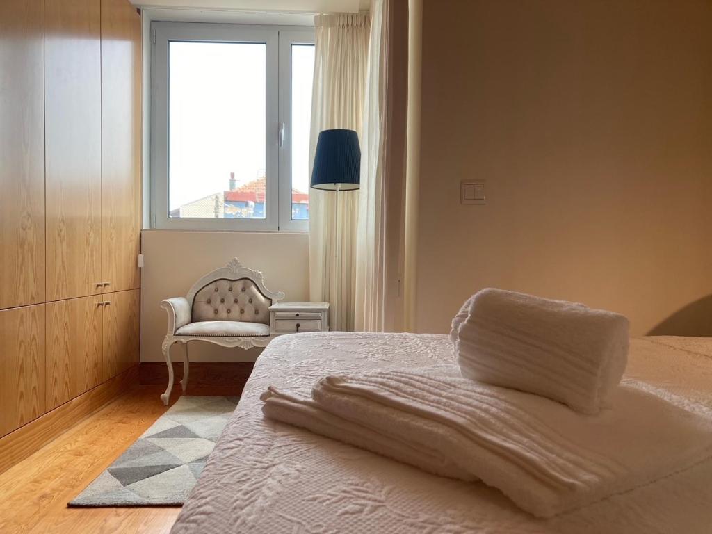 um quarto com uma cama com uma janela e uma cadeira em Gago Coutinho Apartment em São Jacinto
