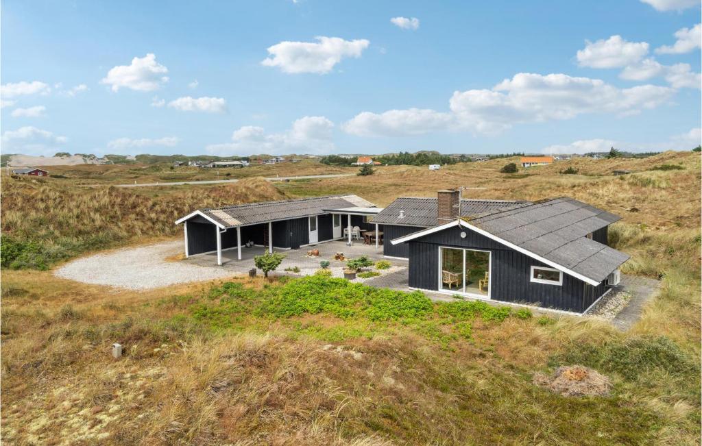 a black house in the middle of a field at Gorgeous Home In Hvide Sande With Sauna in Havrvig