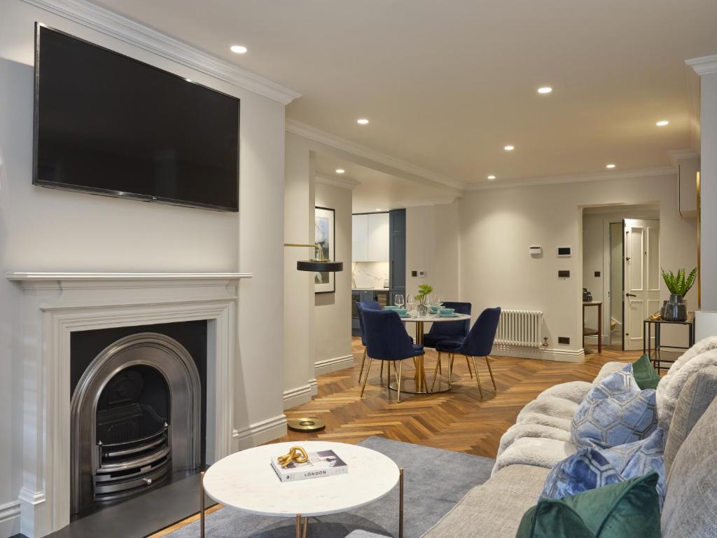 a living room with a fireplace and a tv on a wall at Mayfair - Peterson House by Viridian Apartments in London