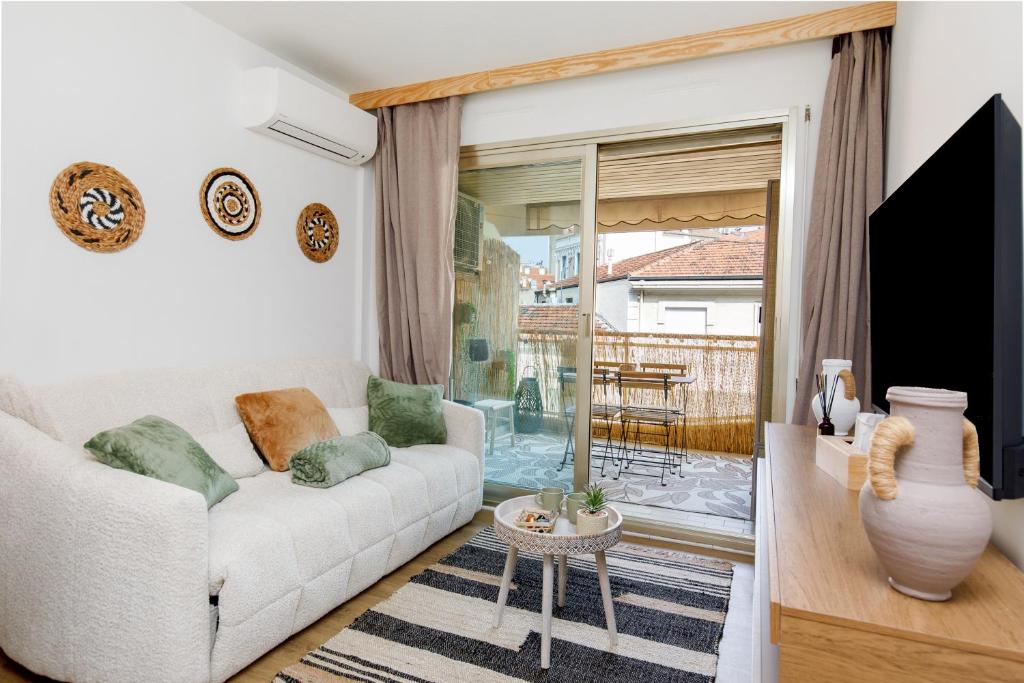 un salon avec un canapé et une porte coulissante en verre dans l'établissement Cannes proche Croisette et palais magnifique appartement 4 couchages, à Cannes