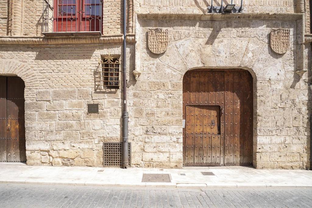 two wooden doors on the side of a brick building at Palacio Rejadorada in Toro