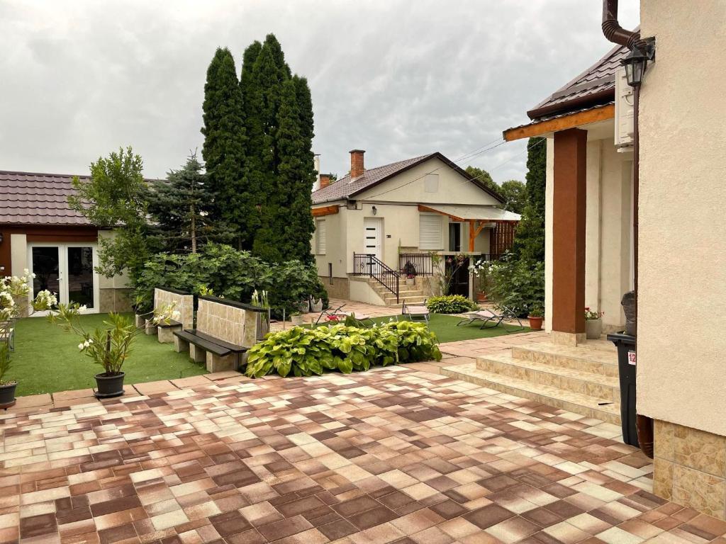 a backyard with a brick patio and a house at Adam Apartman in Hajdúszoboszló