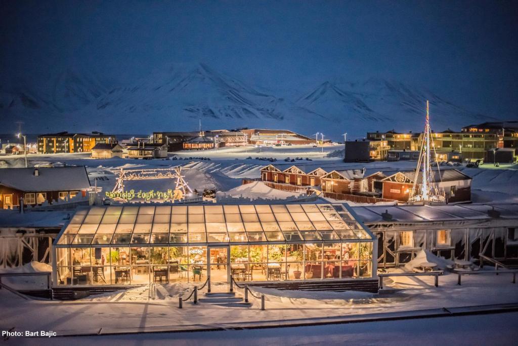 a large glass building in the snow at night at Mary-Ann's Polarrigg in Longyearbyen