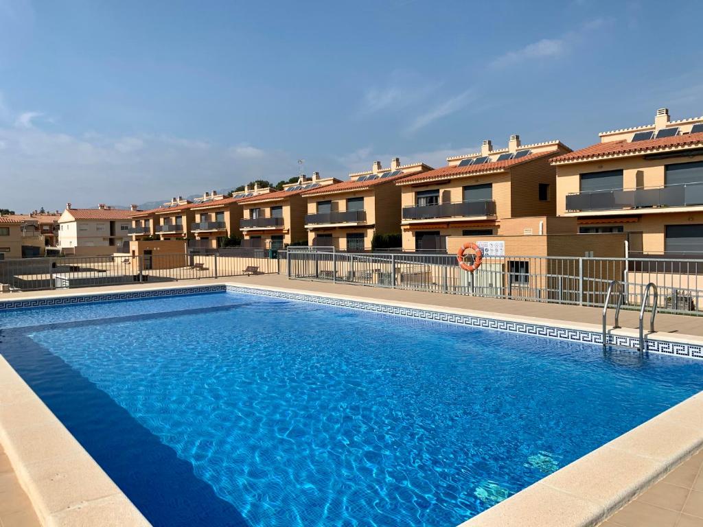 uma grande piscina em frente a alguns apartamentos em TROPIKANA em Miami Platja