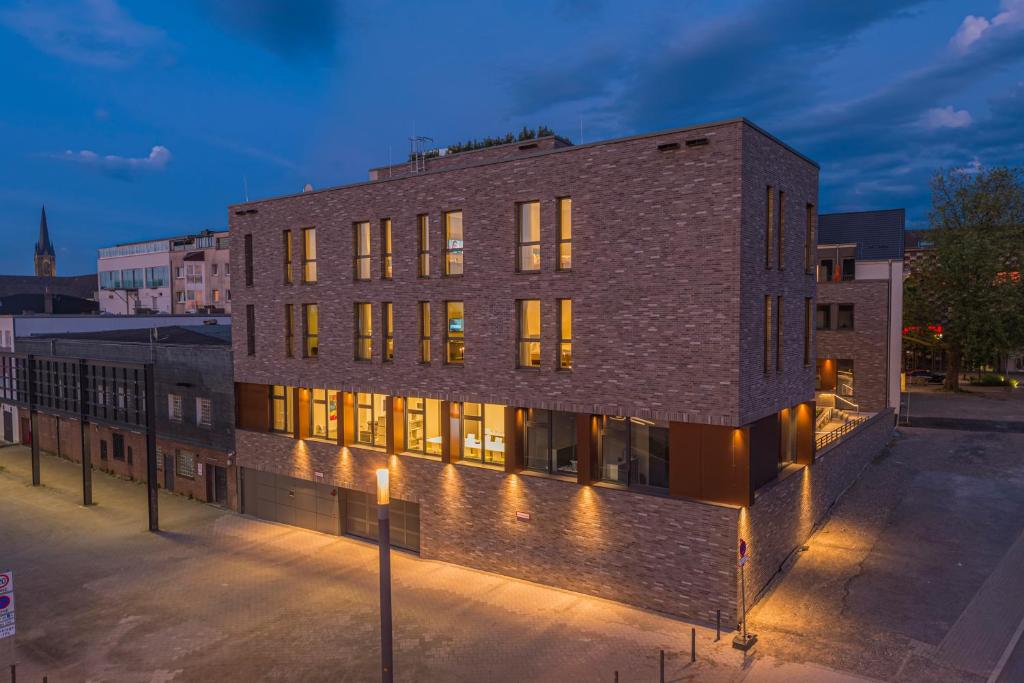 a brick building on a city street at night at Hotel Neues Pastorat in Heiligenhaus