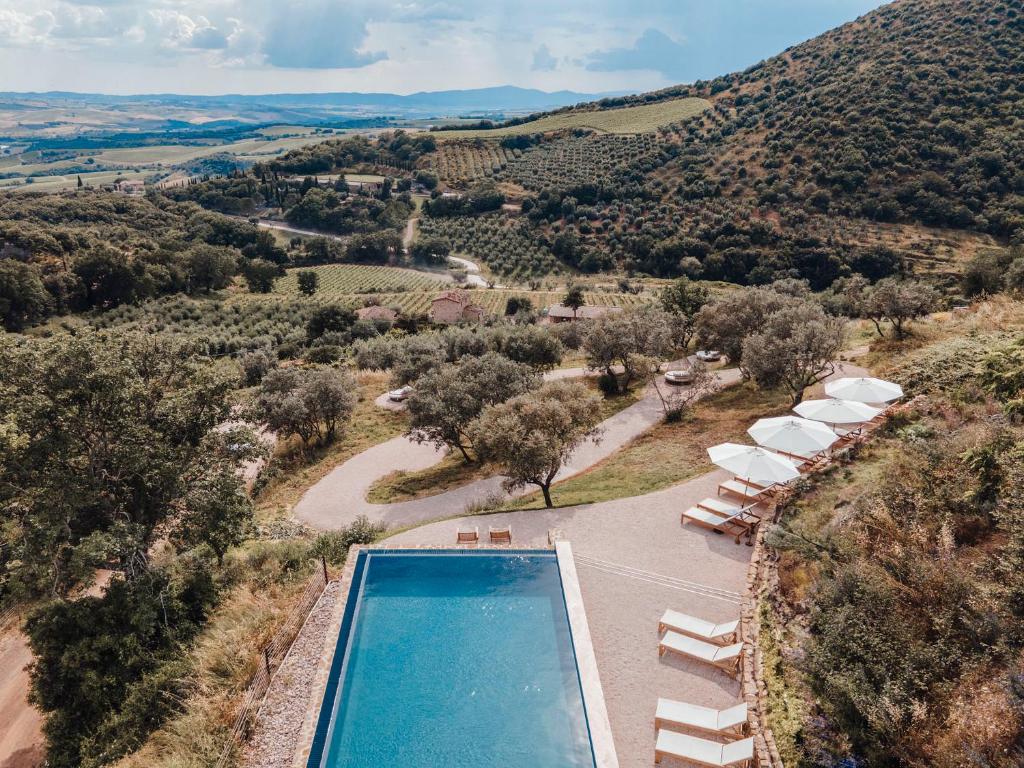 an aerial view of a pool with chairs and umbrellas at Corte Francigena in Montalcino