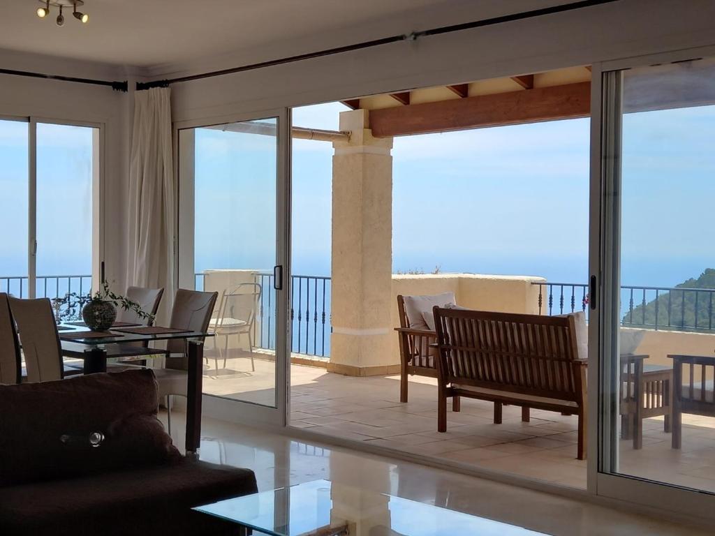 a living room with a balcony with a table and chairs at Villa Suiza in Altea