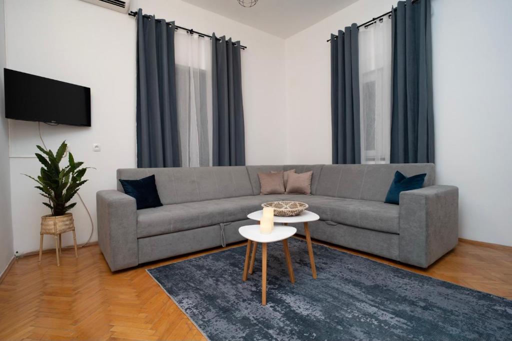 een woonkamer met een bank en een tafel bij Liman Rooms and Apartments in Mostar