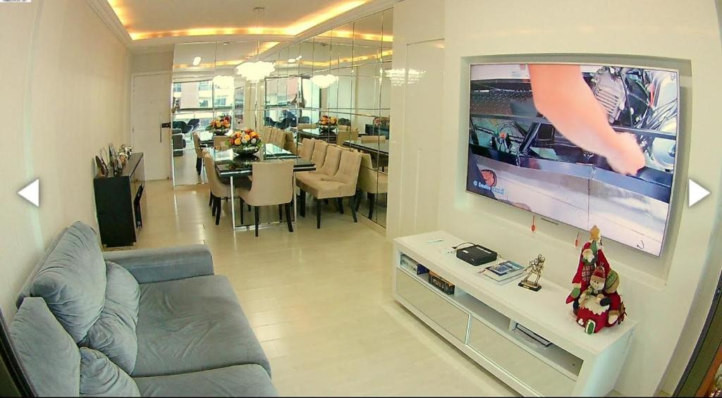 sala de estar con TV de pantalla plana en la pared en Excelente Apartamento Edf Bellagio - Praia do Morro, en Guarapari
