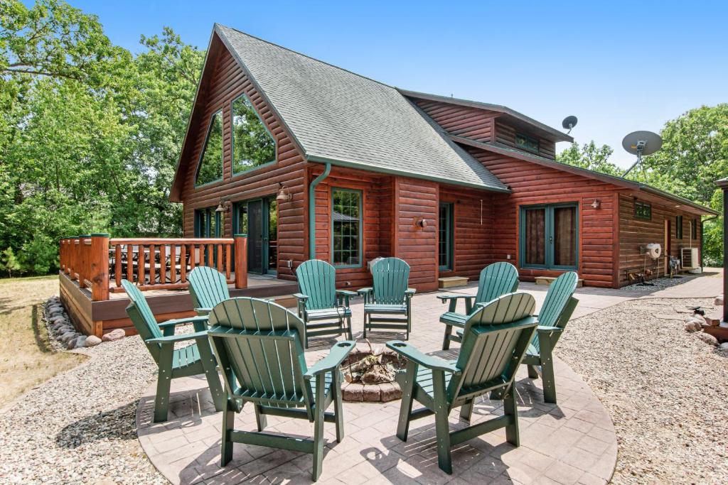 a group of chairs and tables in front of a log cabin at On the Lake at Castle Rock in Necedah