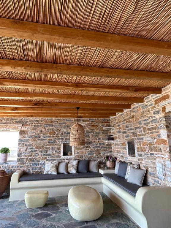 - un salon avec un canapé et un mur en briques dans l'établissement Marikos House, Pyrgaki Alyko Naxos, à Plage d'Aliko