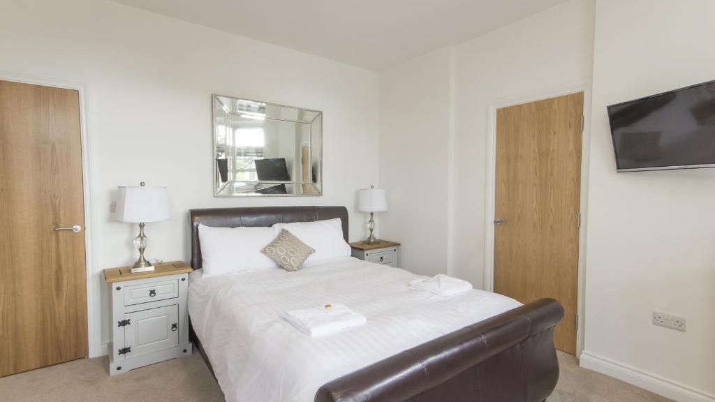 a bedroom with a bed with a chair and a mirror at 3 Bed Edenhurst By Pureserviced in Plymouth