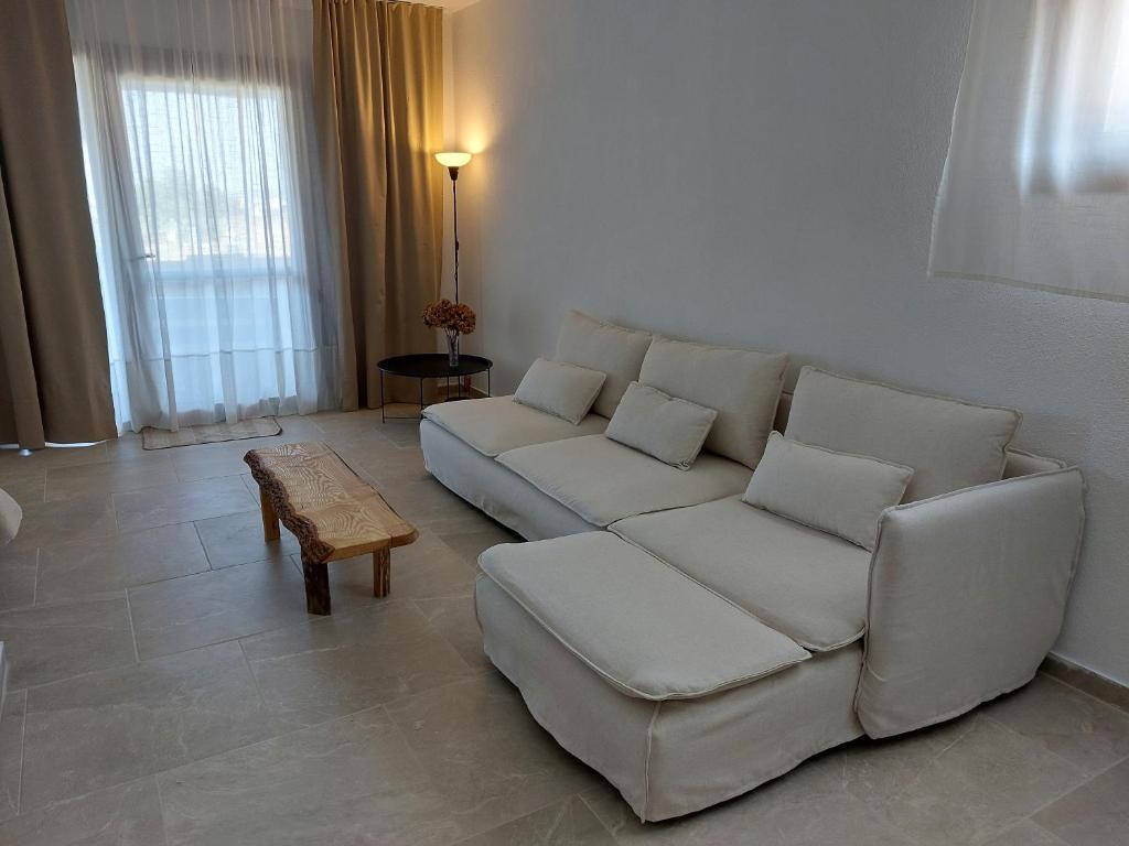 a living room with a white couch and a table at Seastone in Ierissos