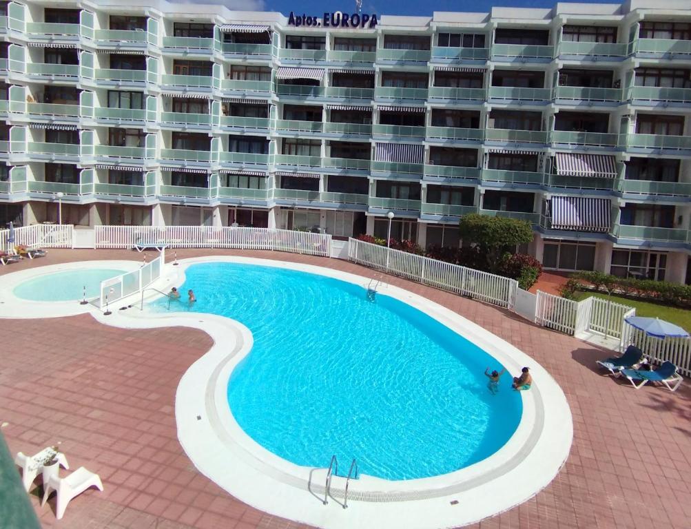 a large swimming pool in front of a large apartment building at Relax Playa Ingles in Playa del Ingles