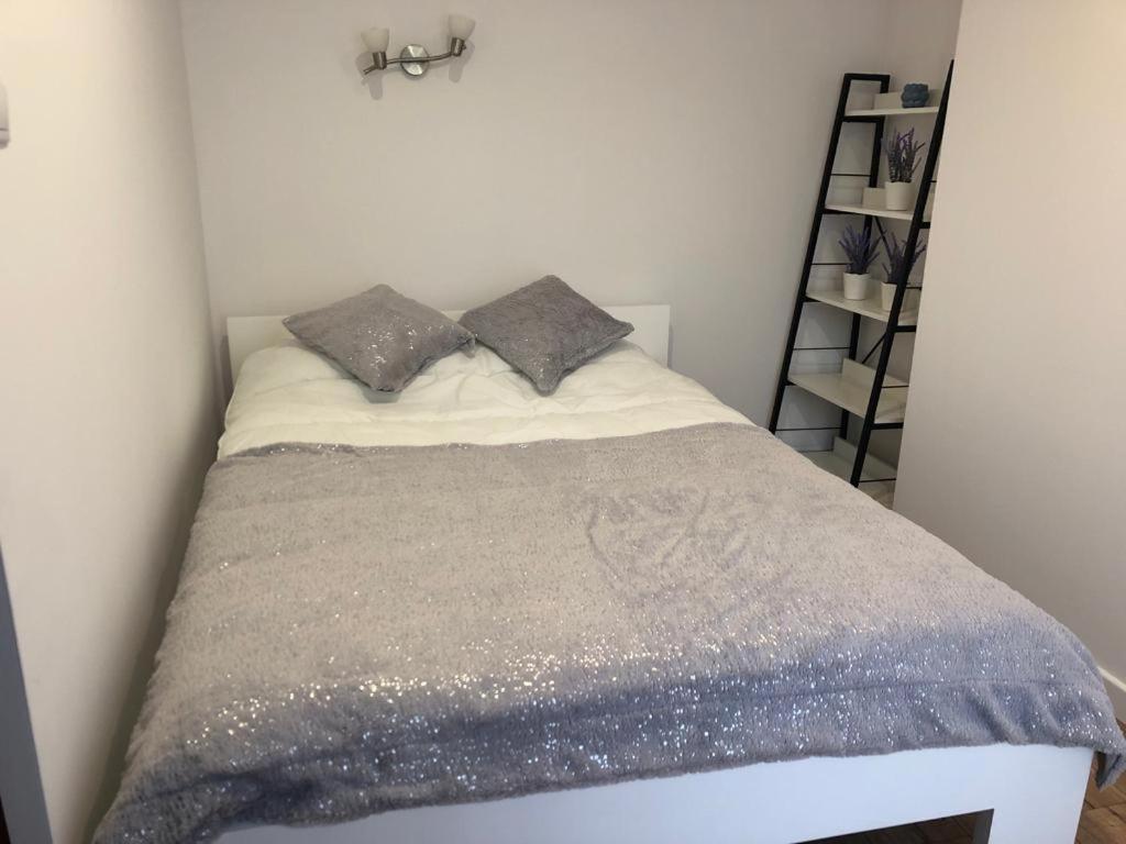 1 dormitorio con 1 cama con manta gris en Apartamenty Harnaś, en Rytro