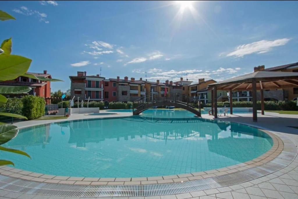 ein großer Pool in einem Resort mit Gebäuden im Hintergrund in der Unterkunft Apartment baglio degli ulivi in Sirmione