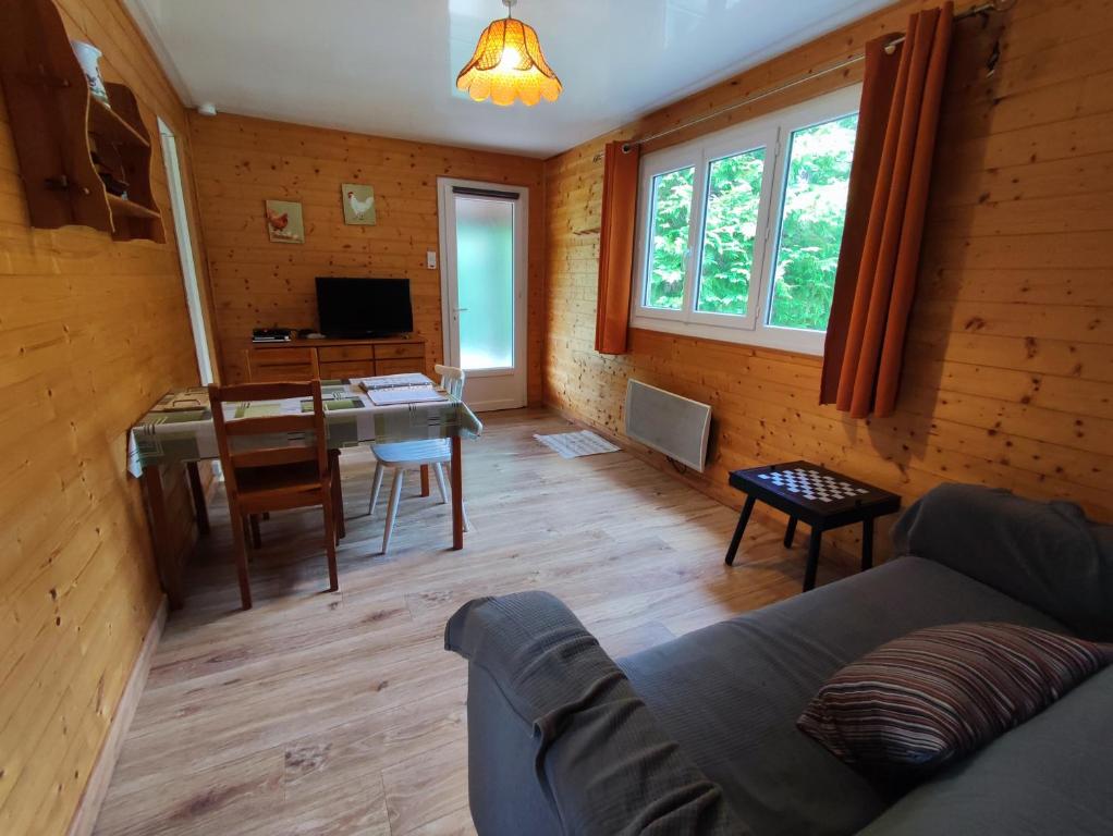 ein Wohnzimmer mit einem Sofa und einem Tisch in der Unterkunft Gite du Domaine Saint Georges in Milly-la-Forêt