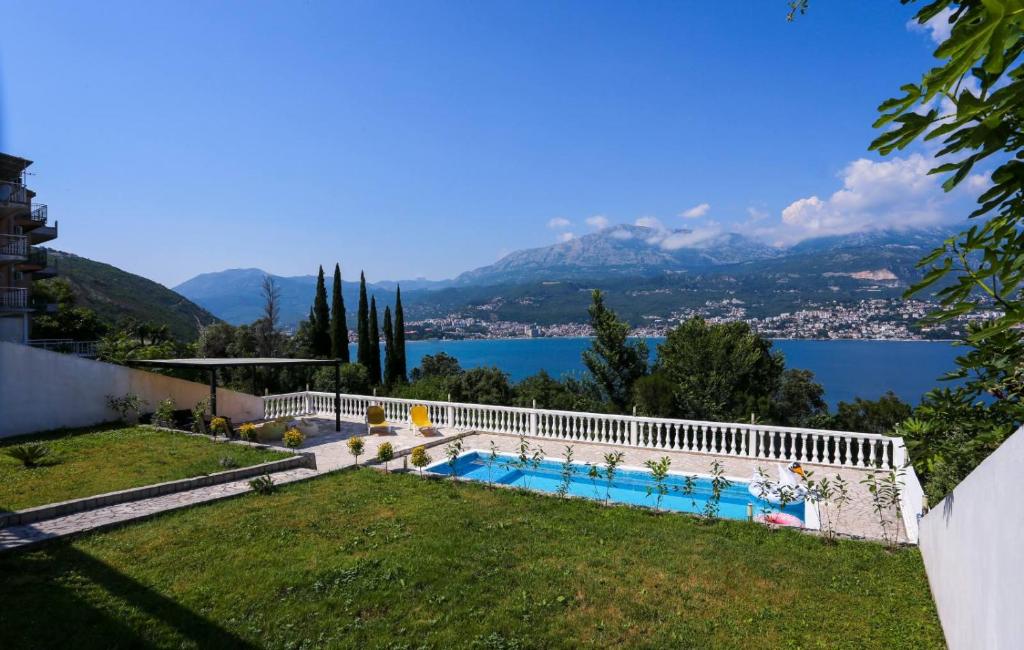 a house with a swimming pool and a view of the water at Mountain Bay View Apartments in Njivice