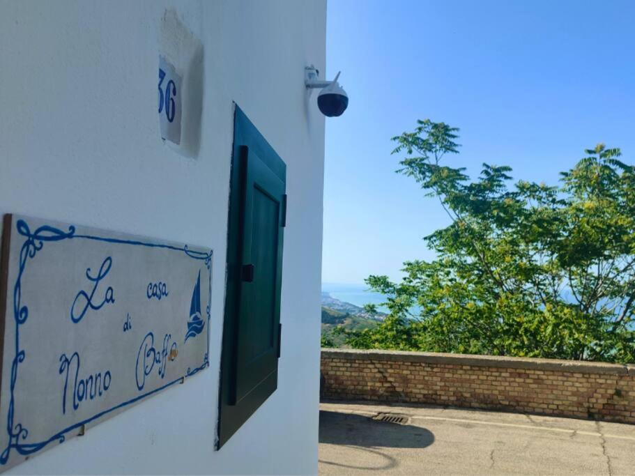 une porte donnant sur un bâtiment avec vue sur un arbre dans l'établissement Homiday - La Casa di Nonno Baffo, à Silvi Paese