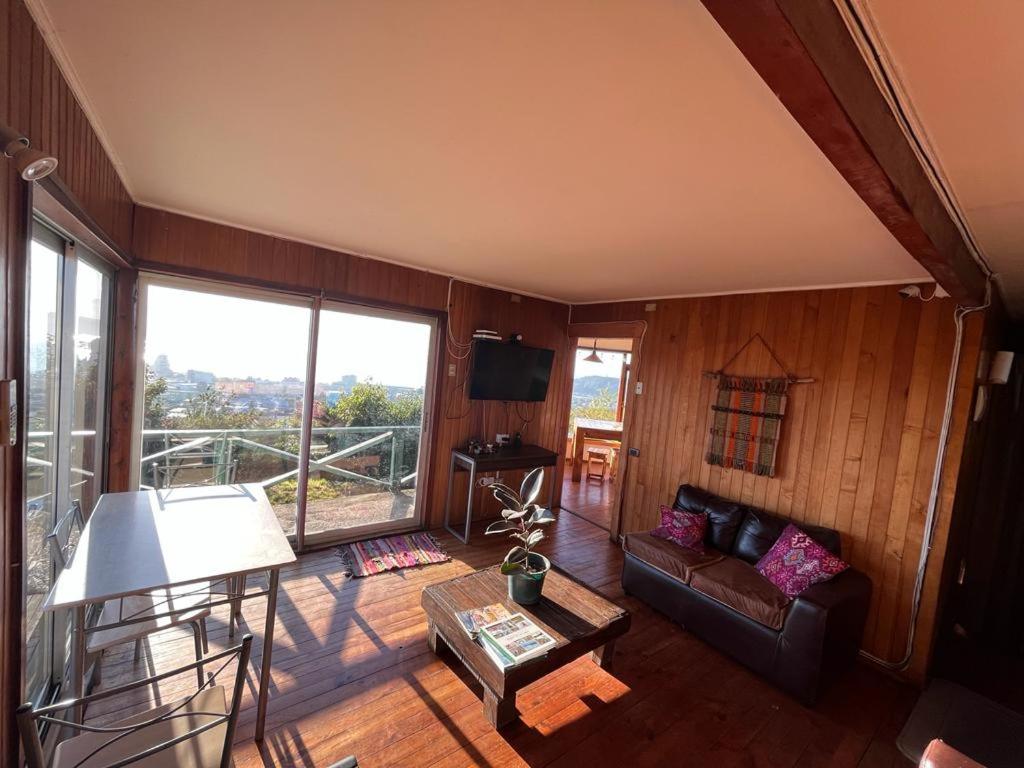 a living room with a couch and a large window at Patagonia Nice View in Puerto Montt