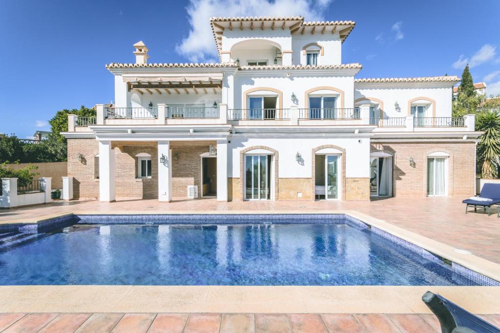 eine Villa mit einem Pool vor einem Haus in der Unterkunft Casa Miguel in Frigiliana